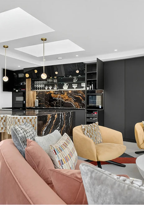Contemporary kitchen open-plan to lounge with dark marble splashback and island